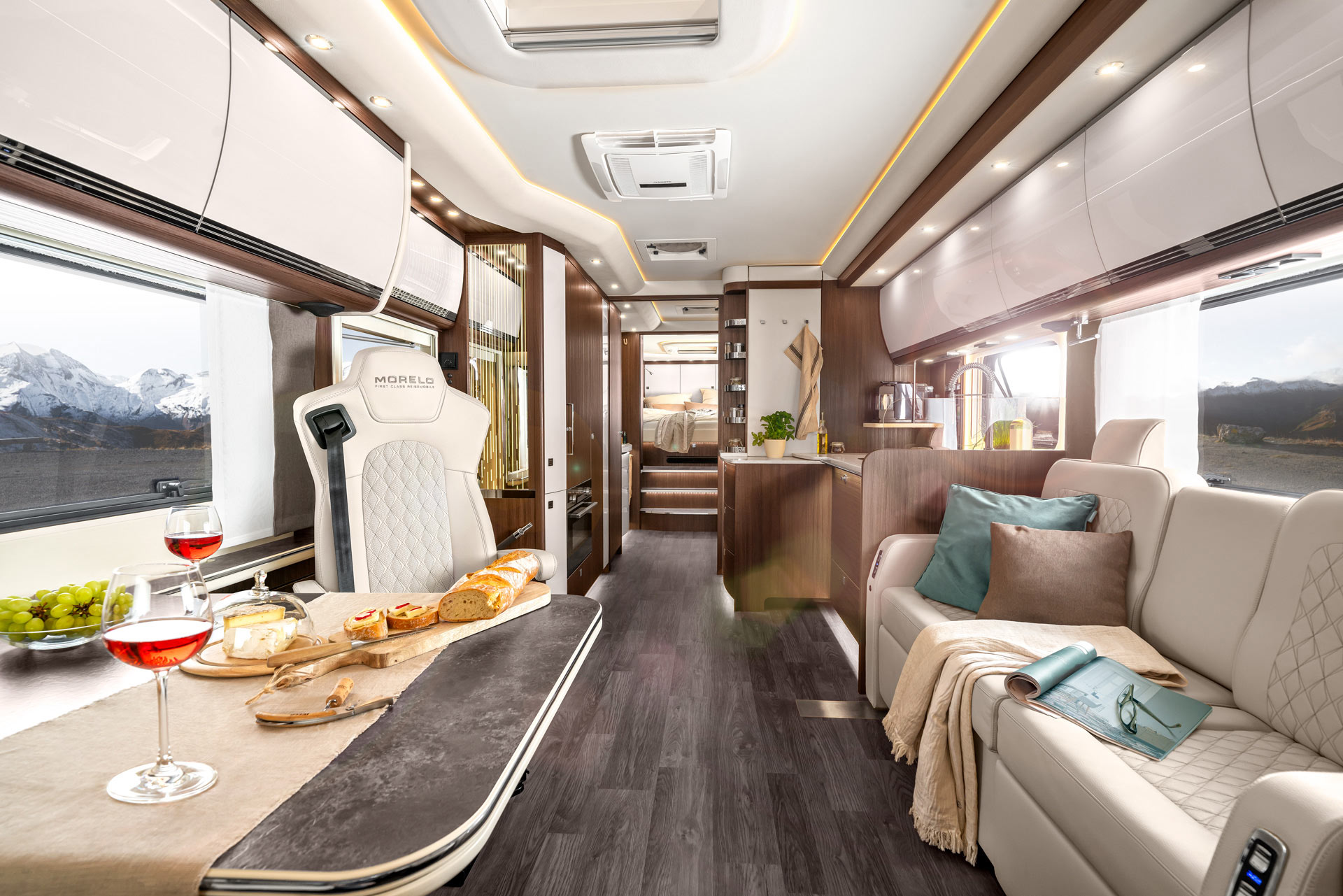 Luxuriöses Wohnmobil mit hellem Interieur, gedecktem Tisch und Panoramablick