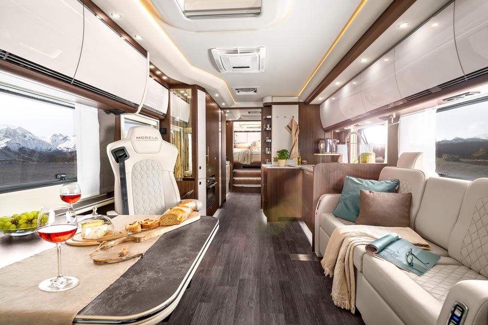 Luxuriöses Wohnmobil Innenraum mit edler Einrichtung, Wein, Käse und Bergblick