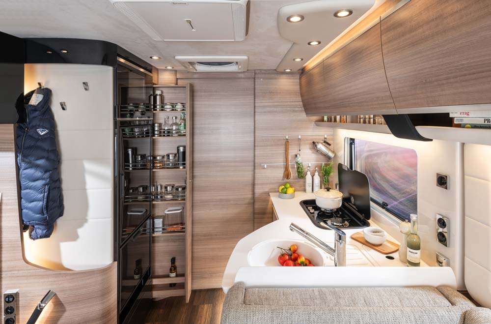 Modern Wohnmobilküche mit hellen Holzfronten, gut bestückt und stilvoll eingerichtet