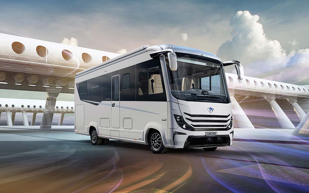 Ein weißer moderner Wohnwagen steht vor einer futuristischen, säulenartigen Kulisse