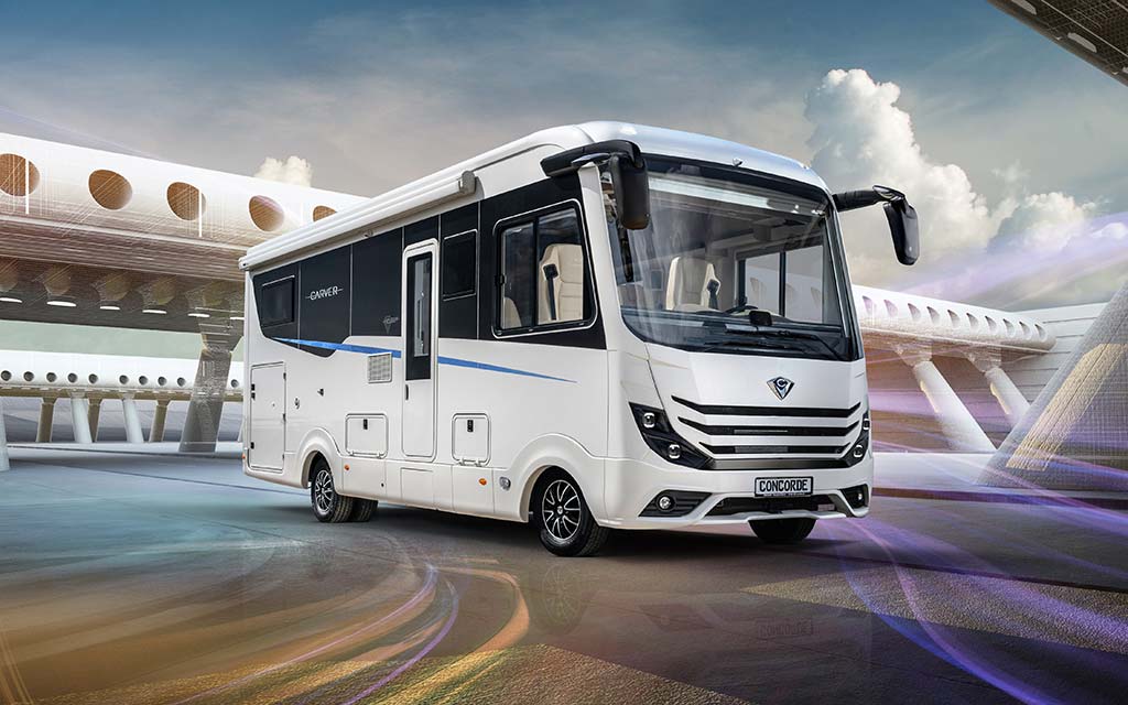 Ein weißer moderner Wohnmobilbus steht vor futuristischer Architektur im Sonnenlicht