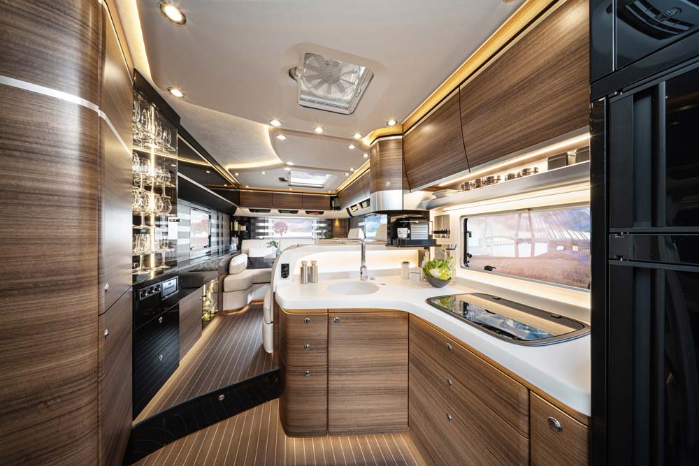 Modern Wohnmobilküche in hellen Holztönen mit elegantem Design und LED Beleuchtung