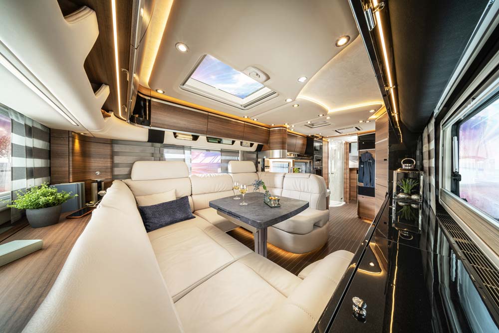 Das luxuriöse beige Wohnmobil bietet gemütliche Sofas, viele Fenster und stilvolle Beleuchtung