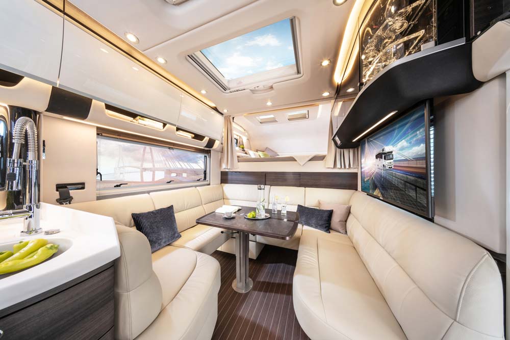 Heller und moderner Wohnmobil Innenraum mit cremefarbenen Polstern und Dachfenster