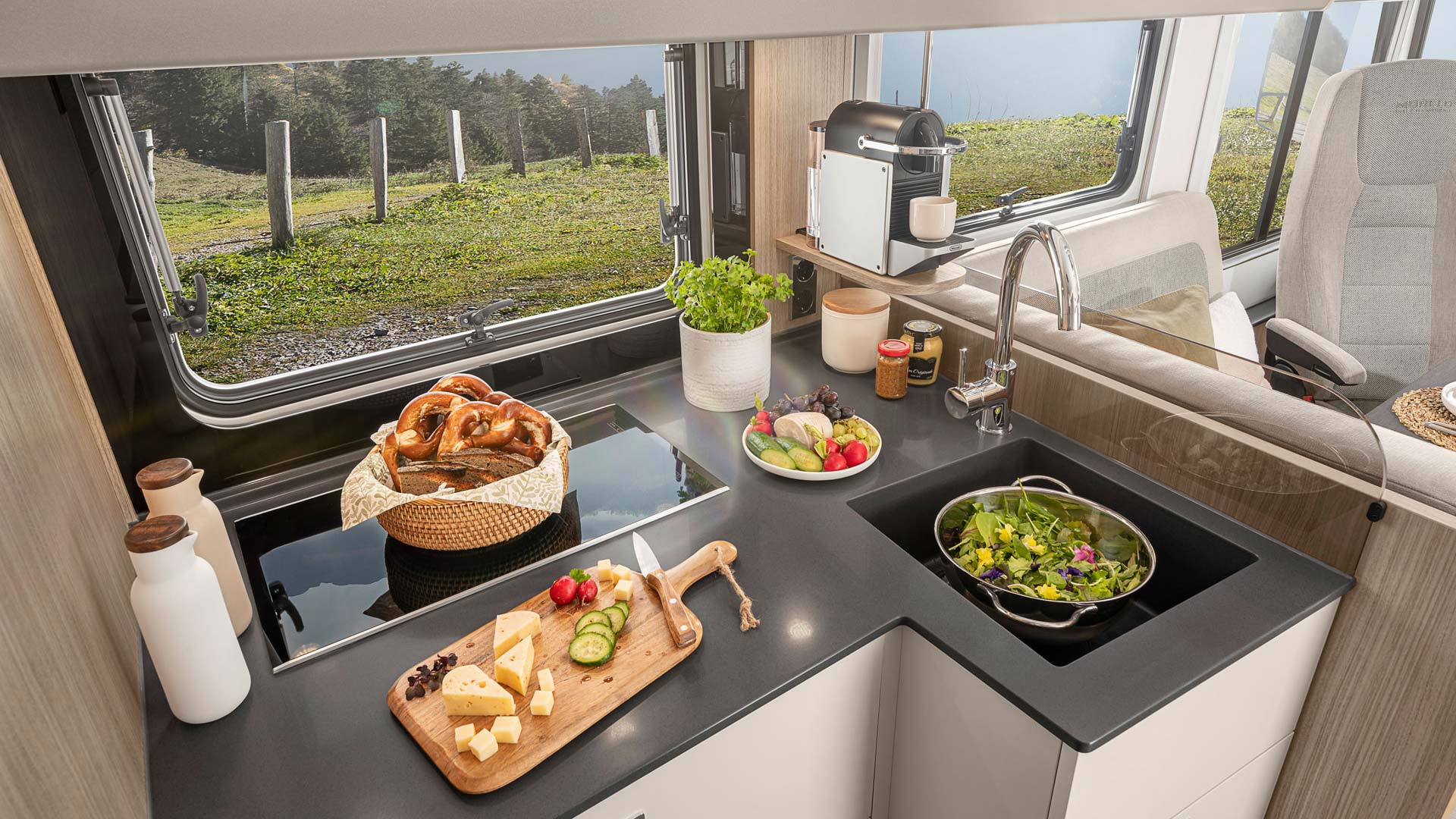 Eine moderne Wohnmobilküche mit frischem Gemüse, Kräutern und Holzarbeitsfläche