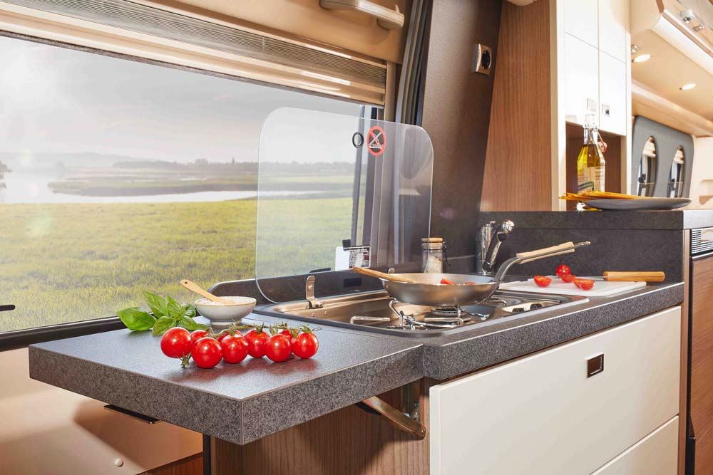 Eine moderne Küchenzeile im Wohnmobil mit Tomaten und frischen Kräutern