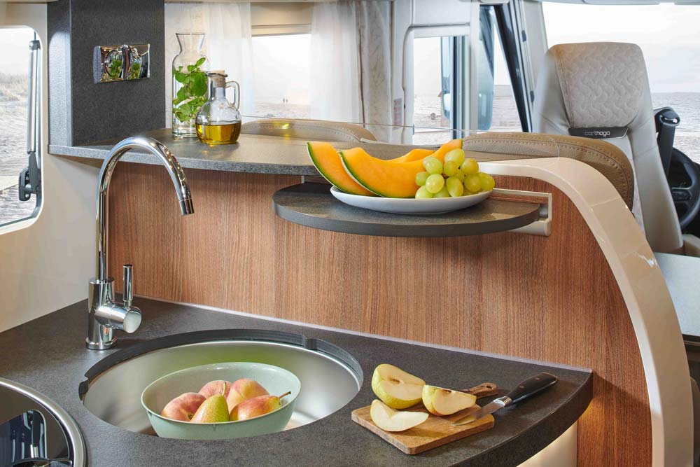 Helles Wohnmobilinterieur mit Obstschale auf Holzarbeitsplatte und frischen Äpfeln