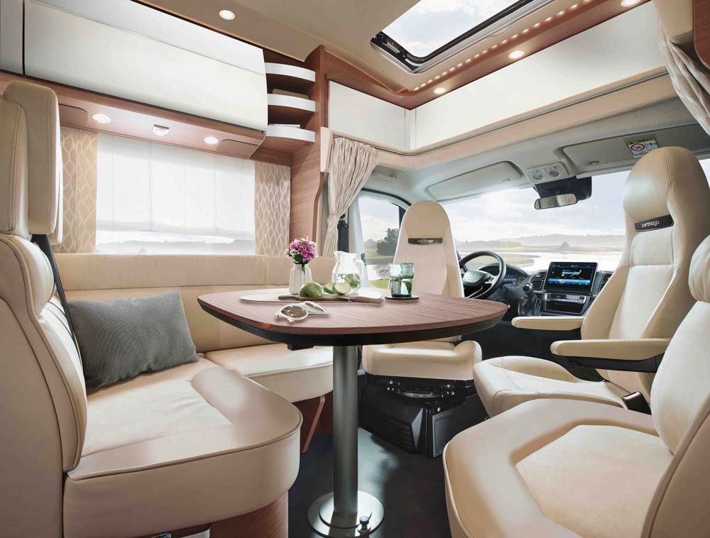 Modern Wohnmobil Innenraum mit hellem Polster, großem Fenster und dekoriertem Tisch