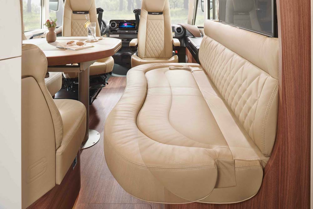 Beiges Sofa mit abgerundeten Kanten in einem modernen Wohnmobil mit Holzelementen