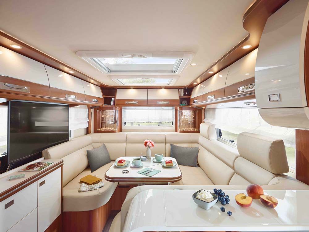 Modern helles Wohnmobil mit beige Lederpolstern und einem einladend gedeckten Tisch