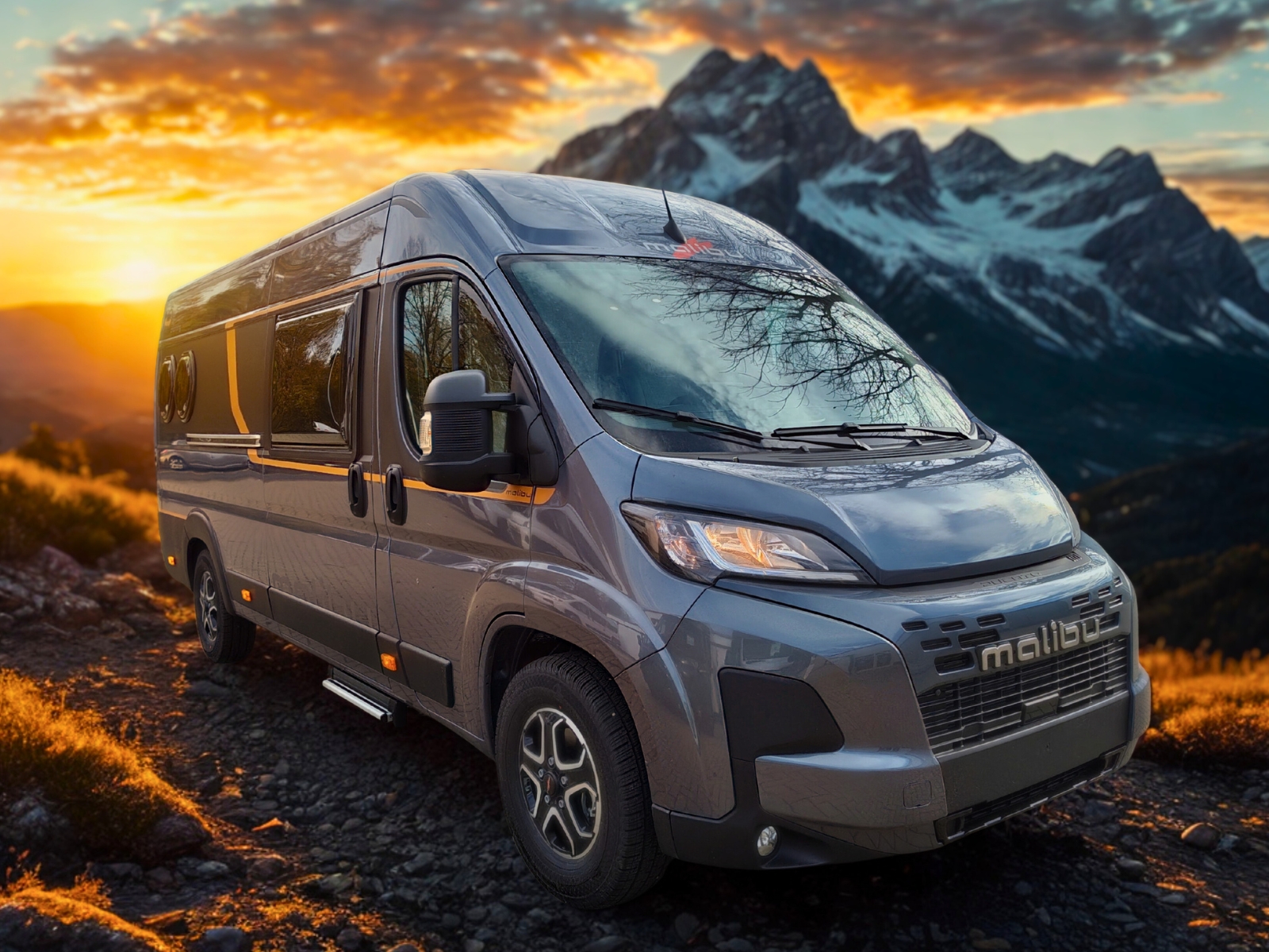 Grauer Malibu Wohnmobil steht vor eindrucksvoller Bergkulisse im Sonnenuntergang