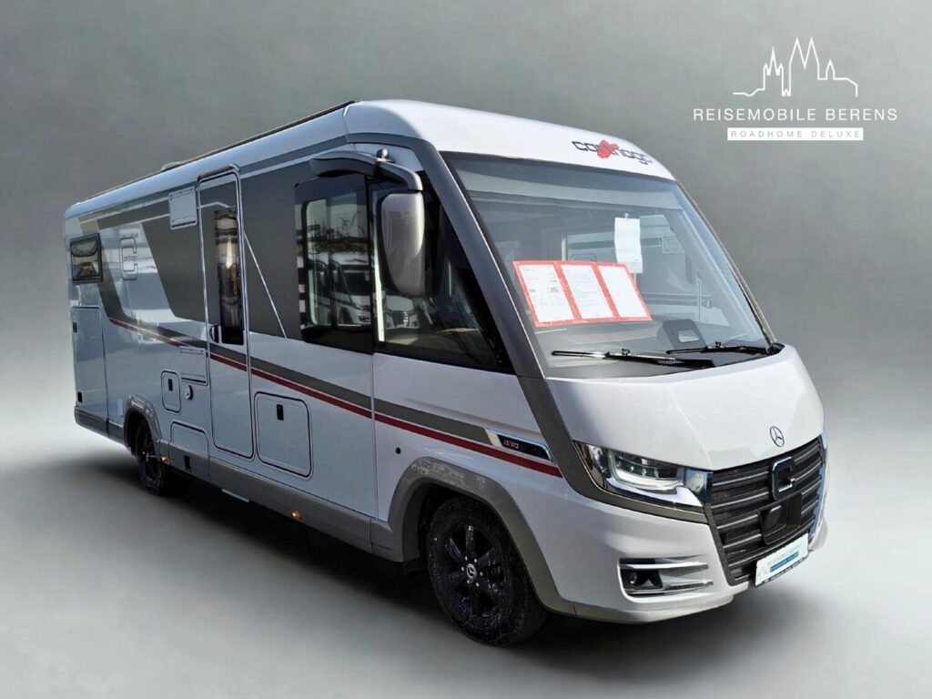 Silbernes Wohnmobil mit roten Zierstreifen vor grauem Hintergrund